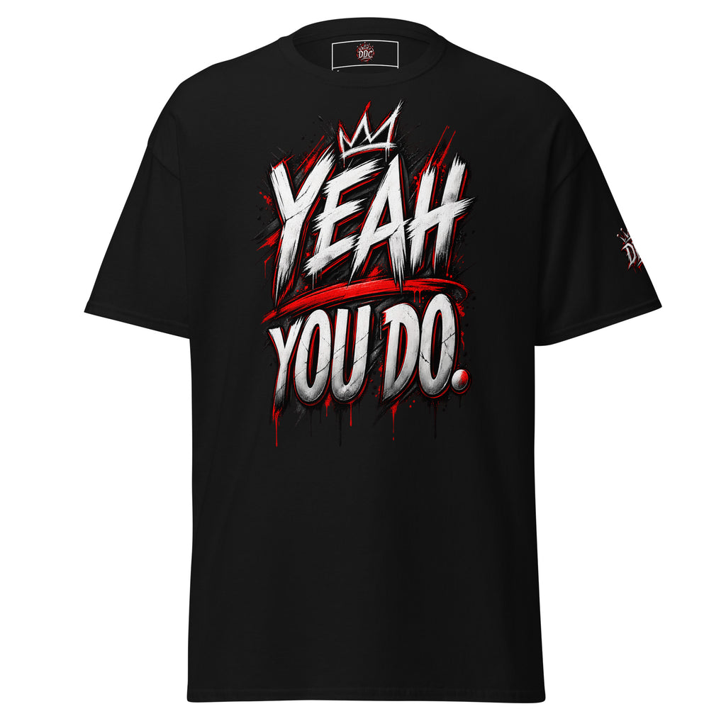 A black short-sleeve t-shirt with a bold graphic on the front reading 'YEAH YOU DO.' in white and red graffiti-style lettering, with a small crown graphic above the text.