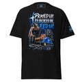 A black short-sleeve graphic t-shirt with a detailed front print featuring a man in a cap, a cross, a helmet, and the text 'PRAYED UP. CLOCKED IN.