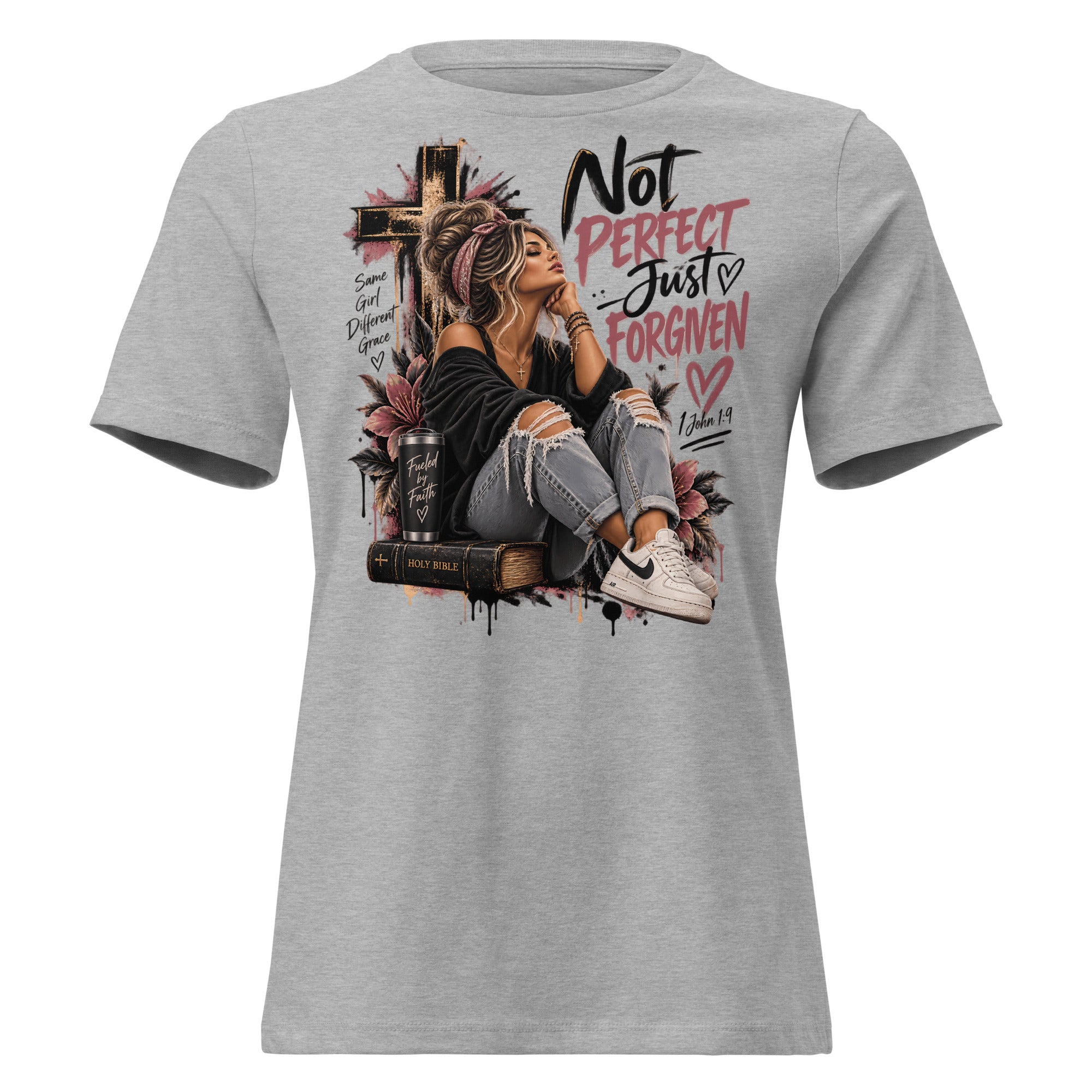 A heather gray short-sleeve t-shirt with a large graphic print on the front. The graphic features a woman sitting on a book next to a cross, with the text 'Not PERFECT Just - Just FORGIVEN' in black and pink lettering.