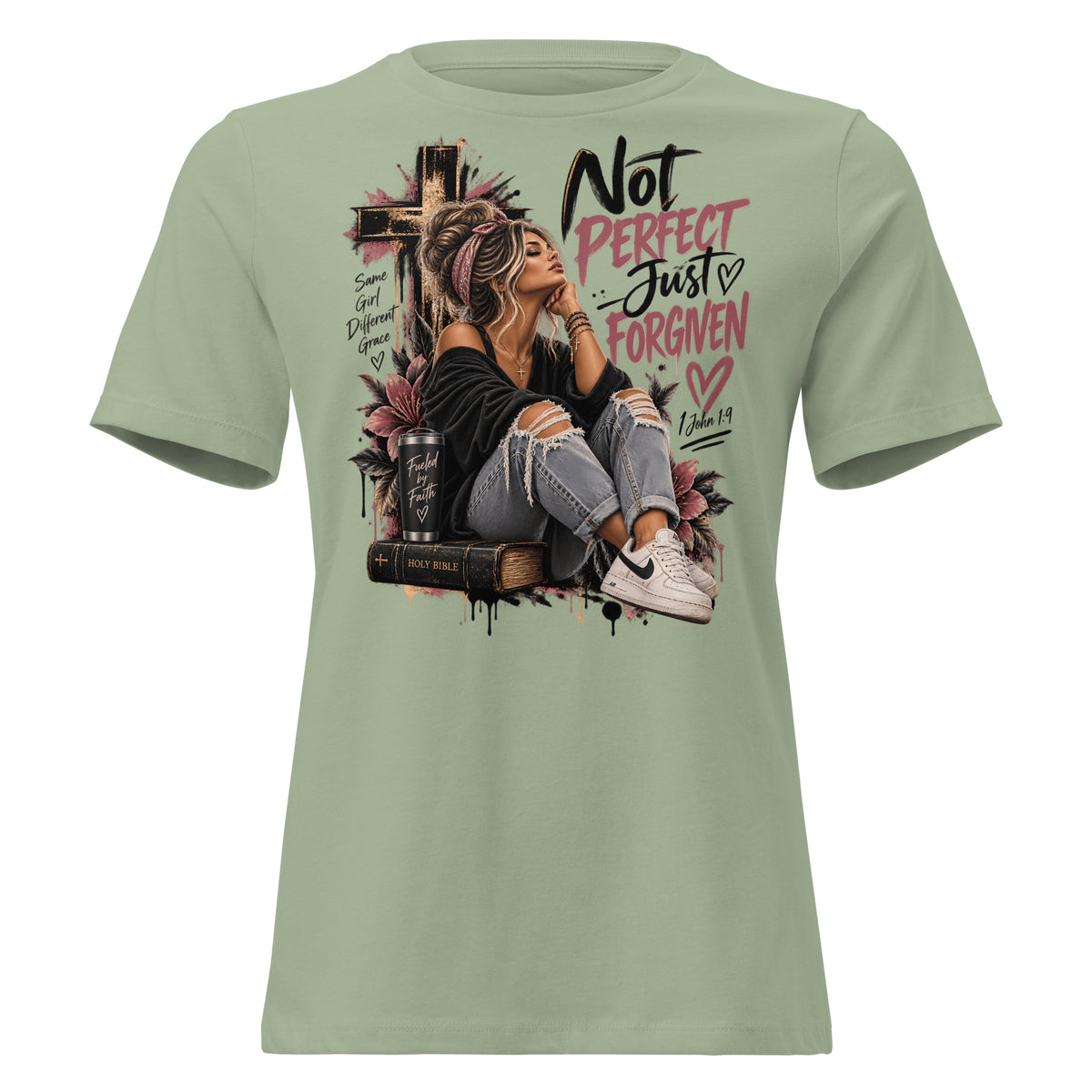 A sage green short-sleeve t-shirt with a large graphic print on the front. The graphic features a woman sitting on a book next to a cross, with the text 'Not PERFECT Just ForGIVEN' and 'Romans 8:15' in black and pink lettering.